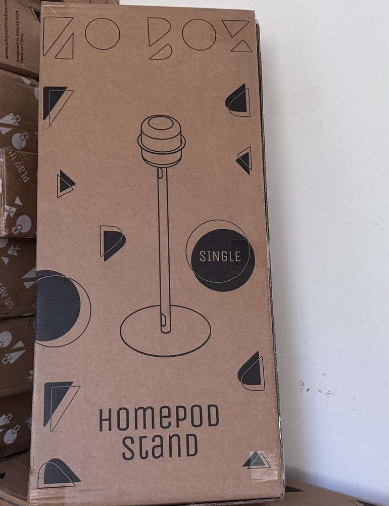 A NoBox HomePod Stand carton standing on a stack of boxed refurbished stock in the Atlanta workshop, waiting to ship. Refurbished stock is the only range NoBox sends overseas.