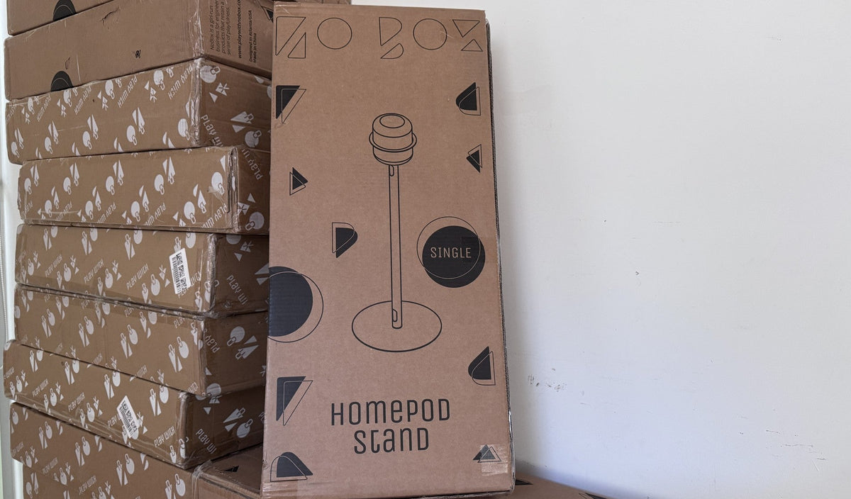 A NoBox HomePod Stand carton standing on a stack of boxed refurbished stock in the Atlanta workshop, waiting to ship. Refurbished stock is the only range NoBox sends overseas.