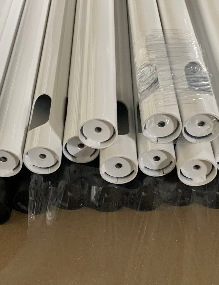 Bundles of white and black NoBox stand posts wrapped and stacked, ready to ship