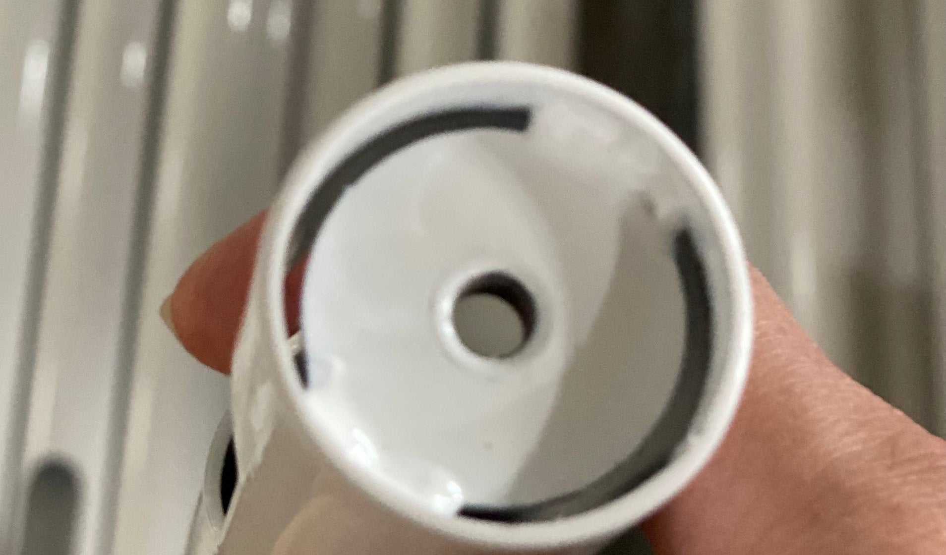 Close view of a new white NoBox post insert seated in the end of a stand tube, held in hand