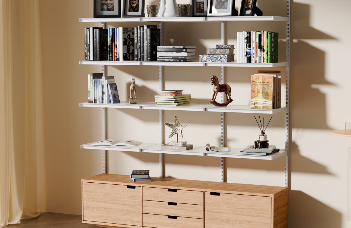 Desh– Joy system wall shelving in a living room, shelves running edge to edge above a wooden credenza