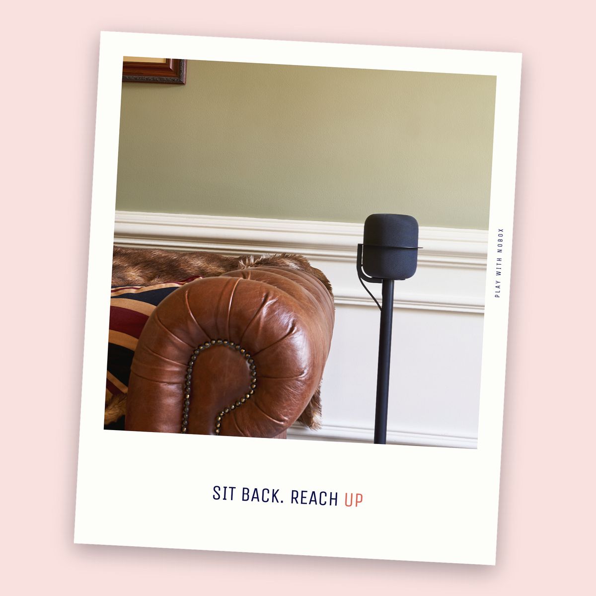 A black NoBox HomePod floor stand placed beside seating, speaker at seated ear height